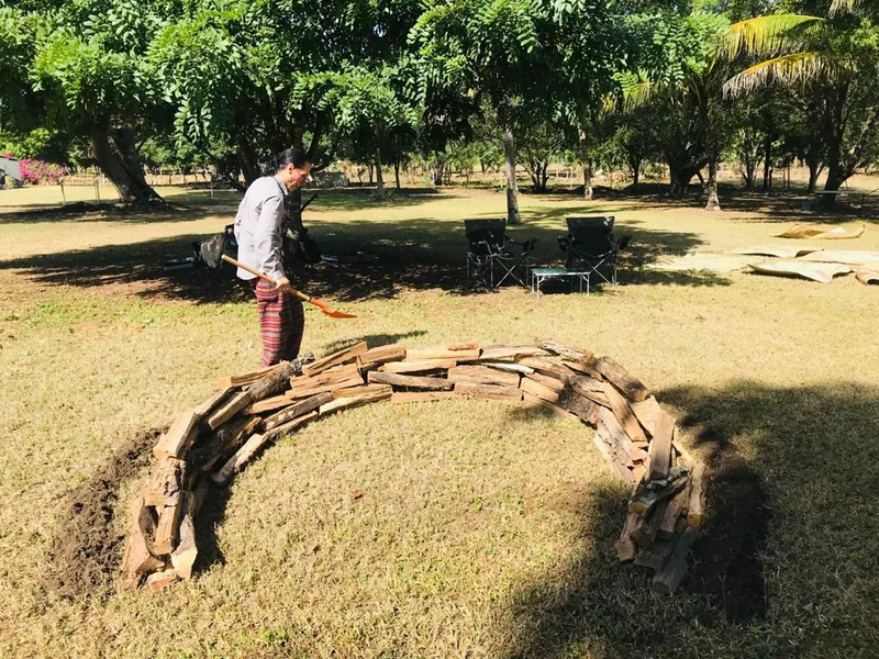 El arco de leña terminado sobre el prado, listo para la ceremonia