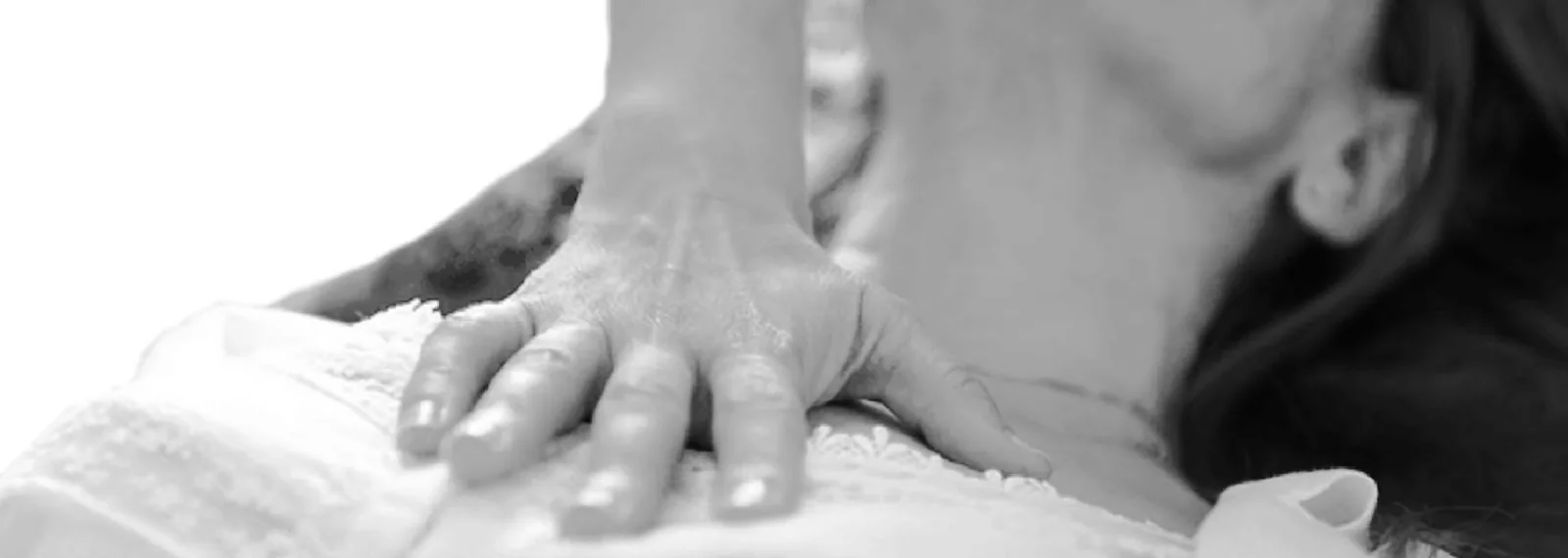 Manos de terapeuta apoyadas suavemente sobre la espalda de una persona durante una sesión de osteopatía bioenergética celular en Centro Cauce